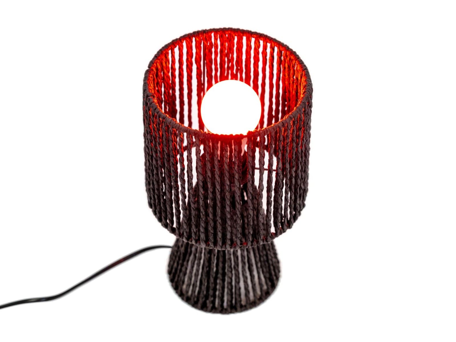 LED žárovka svítí červeně v tkané lampě, pohled shora